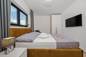 ein Schlafzimmer mit Bett und Flachbildfernseher in der Unterkunft Santalezi Sunset Villa 2 in Santalezi