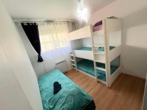 a small room with two bunk beds and a window at Apt Disneyland 2 chambres, parking, bus sur place in Montévrain