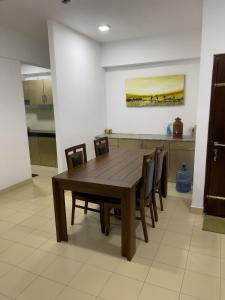 jadalnia z drewnianym stołem i krzesłami w obiekcie Semi Luxury Apartment CMB 02 15th Floor w Kolombo