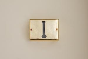 ein Lichtschalter an einer weißen Wand mit einem schwarzen Buchstaben in der Unterkunft Little Heaven Apartments in Sibiu