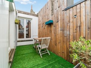 a patio with a wooden fence and a table and chairs at Ijzerstraat 52 - Vakantiewoning 52 in Blankenberge +3 photos