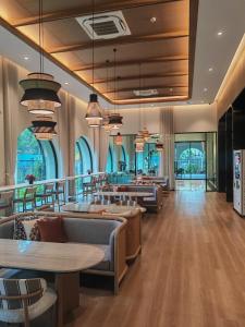 un ristorante con divani, tavoli e finestre di 2 bedroom Apartment Title Legendary Bangtao beach a Bang Tao Beach