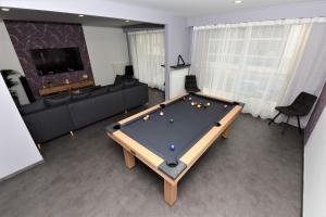 a living room with a ping pong table in it at Le Ray's Inn in Épernay