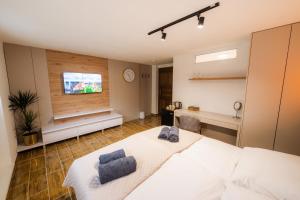a bedroom with a large white bed and a television at Apartmány Slanica in Námestovo