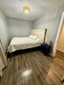 una camera da letto con un letto bianco e un pavimento in legno di Little Blue a Van Buren