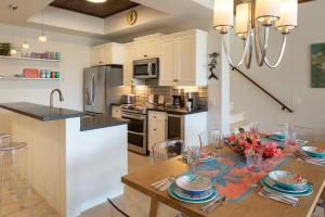 a kitchen and dining room with a wooden table with chairs at Pond Bay Paradise Villa Ocean Views Beach and Kayaks in Monte