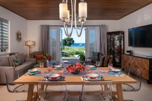 a living room with a dining table with a view of the ocean at Pond Bay Paradise Villa Ocean Views Beach and Kayaks in Monte