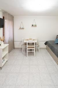 a room with a table and a white tiled floor at Casa Gioia in Chioggia