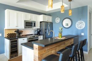 a kitchen with white cabinets and a black counter top at Southern Star Villa Kayaks SUPS Steps to Beach in Monte