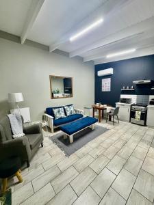un salon avec un canapé bleu et une table dans l'établissement Happy Daze (Self catering), à Swellendam