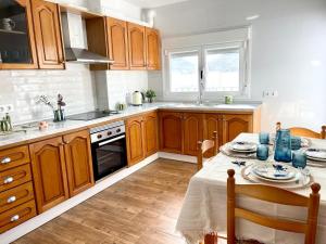 a kitchen with wooden cabinets and a table with blue dishes at El Alfarero Níjar in Níjar
