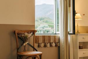 a vase of flowers sitting on a chair in front of a window at Chambre d'hôtes tout confort proche Collioure Côté Saisons in Laroque-des-Albères +39 photos