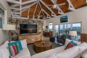 a living room with white furniture and a stone fireplace at Maria Breeze Villa - Stunning Ocean & Sunset Views Private Pool Spacious Rooms in Contant