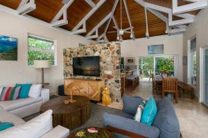 a living room with a couch and a stone fireplace at Maria Breeze Villa - Stunning Ocean & Sunset Views Private Pool Spacious Rooms in Contant
