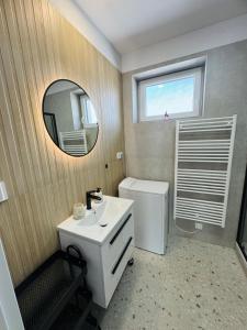 Un baño con un lavabo blanco y un espejo. en Panorama View Apartment, en Veľký Slavkov 4 fotos más
