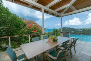 a wooden table and chairs on a deck with the ocean at Maria Breeze Villa - Stunning Ocean & Sunset Views Private Pool Spacious Rooms in Contant +38 photos
