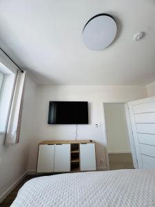 Un dormitorio con una cama y un televisor de pantalla plana. en Panorama View Apartment, en Veľký Slavkov