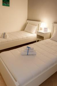 two beds in a room with towels on them at Archè apartment AGRIGENTO in Agrigento +6 photos