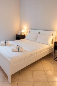 ein großes weißes Bett mit zwei Kissen darauf in der Unterkunft Archè apartment AGRIGENTO in Agrigento