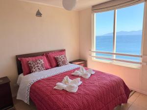 ein Schlafzimmer mit einem Bett mit zwei Handtüchern darauf in der Unterkunft Bahia Pelicanos Apartment in Horcon Puchuncavi in Puchuncaví