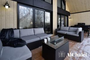 ein Wohnzimmer mit Sofas und einem Tisch in der Unterkunft Charmant Boisé - Nature spa et sauna in Pont-Rouge