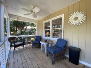 eine Veranda mit Stühlen, einem Tisch und einem Deckenventilator in der Unterkunft Sweet M'Ocean in Edisto Island