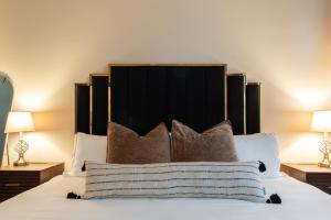 1 cama con cabecero negro y almohadas en The Francesca - Apt 333, en Bryan
