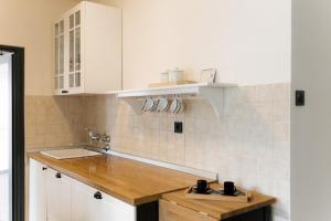 eine Küche mit weißen Schränken und einer Spüle in der Unterkunft Spacious 1BR Designer Apartment in Sloboština in Zagreb