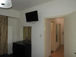 een kamer met een zwarte commode en een televisie aan de muur bij Departamento Centro BA in Buenos Aires
