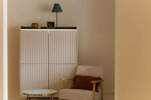 einen Stuhl, einen Tisch und eine Lampe in einem Zimmer in der Unterkunft Spacious 1BR Designer Apartment in Sloboština in Zagreb