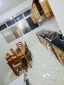 cocina con fogones, mesa y sillas en Conforto de um Lar, en Ponta do Sol