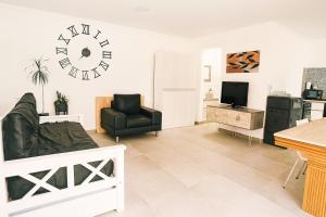 Departamento LUNA NUEVA في سانتا كلارا ديل مار: غرفة معيشة مع أريكة وساعة على الحائط