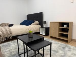 Un dormitorio con una cama con una mesa negra y una mesita de noche. en Le cocon douillet, en Oyonnax