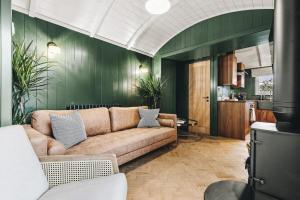 a couch in a living room with green walls at Nestledstays - The Hide in Walberton