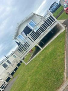 a white house with a lot of windows and chairs at Thornwick Bay Holiday Village - Holiday Accommodation 20633 in Flamborough