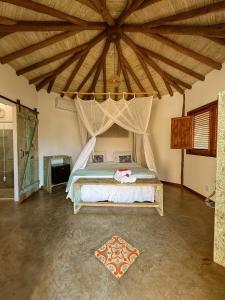 a bedroom with a bed with a large wooden ceiling at Pousada Vila Cacau in Serra Grande