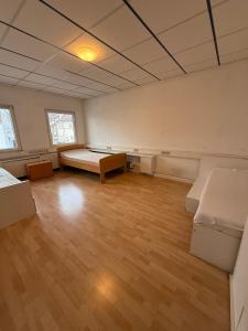 une chambre vide avec deux lits et un plancher en bois dans l'établissement Monteurzimmer & Monteurwohnung Reichenbach an der Fils, à Reichenbach an der Fils