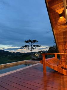 une véranda en bois avec un banc sur une terrasse dans l'établissement Cabana Catuaí, à Espera Feliz 32 autres photos