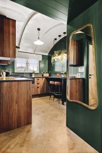 a kitchen with green walls and a mirror at Nestledstays - The Oak in Walberton +36 photos