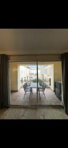 taras ze stołem i krzesłami na balkonie w obiekcie Maison ou chambres a louer place de L'Esplan w mieście Saint-Paul-Trois-Châteaux