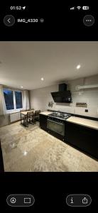 kuchnia z kuchenką i stołem w obiekcie Maison ou chambres a louer place de L'Esplan w mieście Saint-Paul-Trois-Châteaux