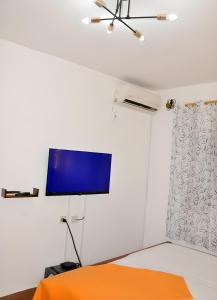 a bedroom with a flat screen tv on a wall at Charmant Douillet à Etoudi in Yaoundé +10 photos