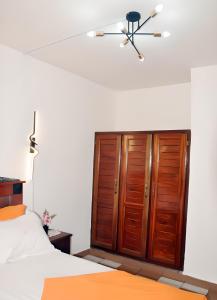 a bedroom with a bed and a wooden cabinet at Charmant Douillet à Etoudi in Yaoundé