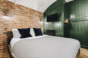 a bedroom with a large bed with a brick wall at Nestledstays - The Oak in Walberton