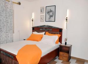 a bedroom with a bed with orange and white pillows at Charmant Douillet à Etoudi in Yaoundé