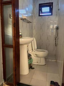 un baño con inodoro y lavabo en Wekati Aldeamento Turístico, en Chaunlundo