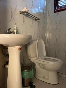 Un baño con un inodoro blanco y un lavabo. en Wekati Aldeamento Turístico, en Chaunlundo