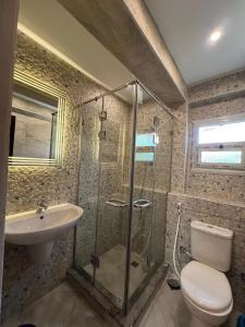 une salle de bains avec douche, toilettes et lavabo dans l'établissement شيراتون للخدمات الفندقيه الفاخره, au Caire