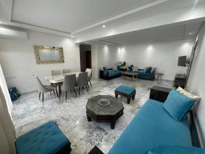 Una sala de estar con un sofá azul y una mesa. en Appartement neuf luxe OLM à Rabat, en Rabat