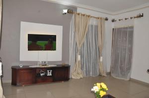 a living room with a television on a table at Charmant Douillet à Etoudi in Yaoundé